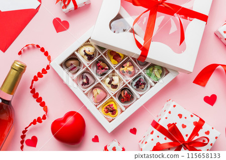 top view photo of st valentine day decor shopping, bag, wine, bottle, envelope, gift, box, candy and red heart on colored background with empty space. Frame background 115658133