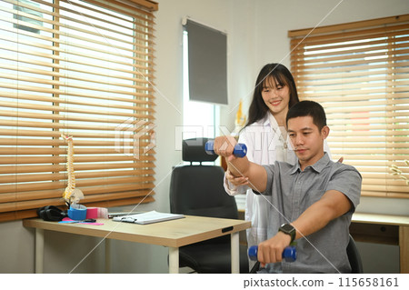 Physiotherapist helping male patient exercising with light weight dumbbells during muscle rehabilitation physiotherapy Physiotherapist helping male patient exercising with light weight dumbbells during muscle rehabilitation physiotherapy 115658161