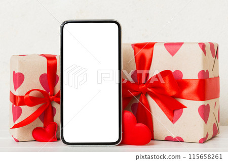 mobile phone with blank screen on colored background with hearts, calendar and gift box, valentine day concept perspertive view flat lay mobile phone with blank screen on colored background with hearts, calendar and gift box, valentine day concept perspertive view flat lay 115658261