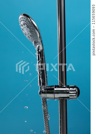 Shower head leak water from hoses plumbing in bathroom as water clogged drop. Blue bathroom  background isolated. Leaking water from chromium stainless steel shower head 115659093