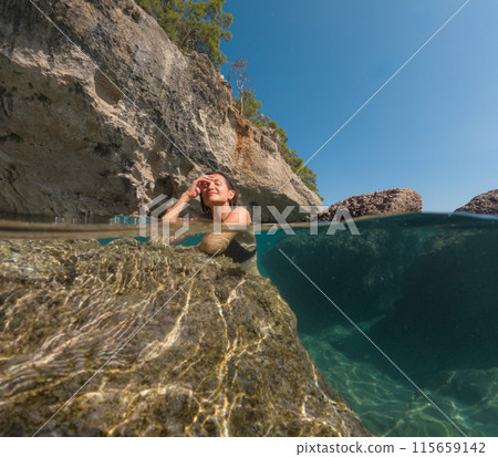 Woman on tropical vacation paradise on sea. Summer sea joy in Turkish seacoast, beaches along Lycian Way, Turkish Riviera. Asian female underwater and turquoise ocean around. 115659142