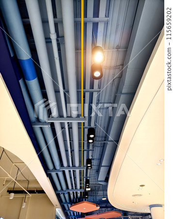 Ceiling with pipes and lights in creates industrial a pattern Ceiling with pipes and lights in creates industrial a pattern 115659202