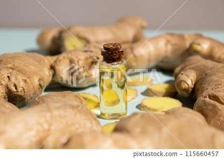 Natural ginger oil in glass bottle among ginger roots 115660457