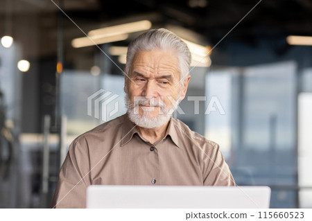 Senior man working on laptop in a modern office setting, looking thoughtful. Ideal for business, technology, and professional work themes. 115660523