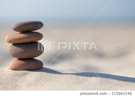 Stacked Pebbles on Sandy Beach Stacked Pebbles on Sandy Beach 115661548