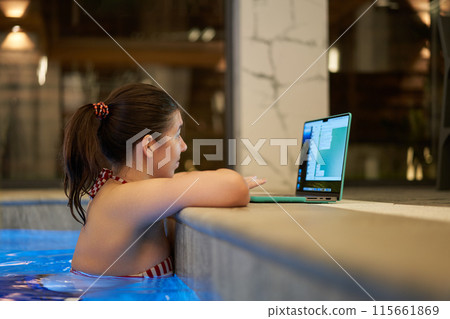 Woman Checking Laptop While in Swimming Pool 115661869