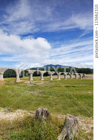 Hokkaido / The Taushubetsu Bridge (Taushubetsu River Bridge), an arch bridge said to be a phantom bridge, is in full bloom under the blue summer sky. 115662310