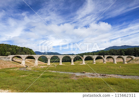 Hokkaido / The Taushubetsu Bridge (Taushubetsu River Bridge), an arch bridge said to be a phantom bridge, is in full bloom under the blue summer sky. 115662311