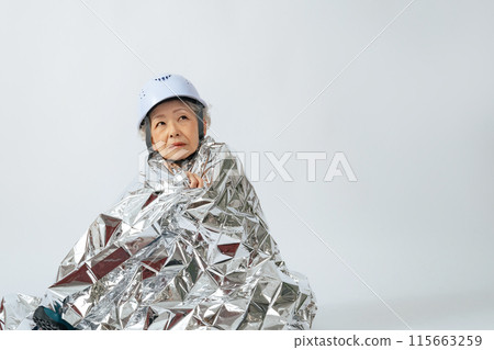 Senior woman wrapped in a survival sheet Senior woman wrapped in a survival sheet 115663259