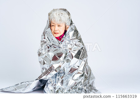 Senior woman wrapped in a survival sheet 115663319