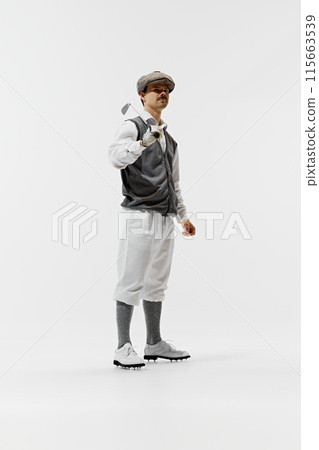 Spirit of vintage golf, this man poses with a golf club, showcasing a look from a bygone era. Man, golfer isolated on white background. 115663539