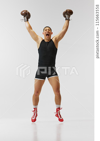 Achievement, success, victory. Full-length of emotions man, boxer in gloves showing his emotions after winning battle isolated on white background. Achievement, success, victory. Full-length of emotions man, boxer in gloves showing his emotions after winning battle isolated on white background. 115663558