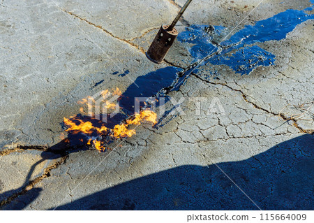 Asphalt cracks are heated before they are filled with hot bitumen emulsion in parking lots to restore joint seals 115664009