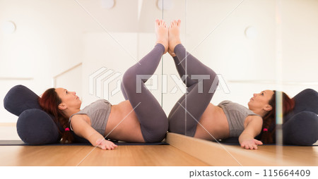 Pregnant woman is engaged in yoga. Bent Candle Pose or Viparita Karani 115664409