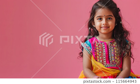 A young girl dressed in vibrant, traditional Indian attire with intricate embroidery 115664943
