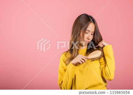 Young beautiful Asian woman upset with a comb and problem hair, Portrait female shocked suffering from hair loss problem, studio shot isolated on pink background, medicine health concept 115665056