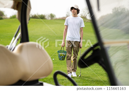 Vehicle in a golf club with young golfers inside 115665163