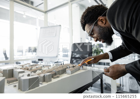 Professional man architect solving engineering problems in his workplace Professional man architect solving engineering problems in his workplace 115665255