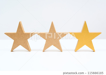 Three star-shaped wooden blocks lined up 115666185