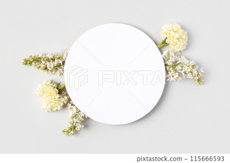 Spring flower frame made of white lilac and white daffodils on gray background with a place for text in the middle. Flat lay, copy space 115666593