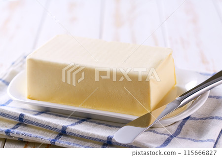 butter and knife on a kitchen table, selective focus. 115666827