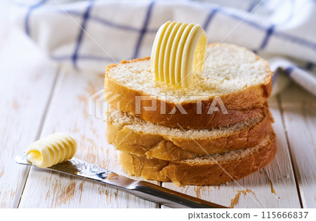 slices of wheat bread with fresh butter curls on a light table. slices of wheat bread with fresh butter curls on a light table. 115666837