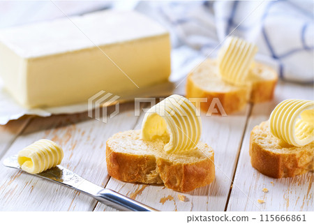 French bread Baguette and butter curls on a kitchen table,selective focus. 115666861