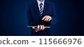 Businessman in a suit using a tablet, standing against a dark background. Ideal for business, technology, and professional concept 115666976