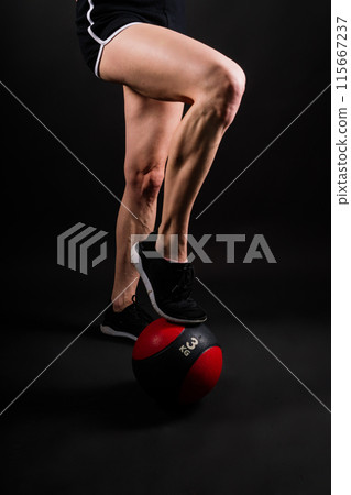 Fitness happy fit woman standing holding a medicine ball. Slim caucasian cross fit woman with fitness ball 115667237