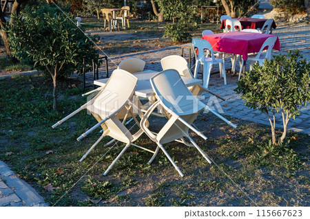 Chairs stand neatly resting beautifully on a table in a street cafe Chairs stand neatly resting beautifully on a table in a street cafe 115667623