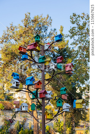 Multicolored birdhouses adorning a metal tree 115667625