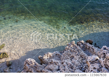 Clear water shoreline on rocky beach 115667630