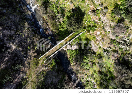 Medieval narrow stone bridge crossing river. Akapnou village, Limassol District, Cyprus 115667807