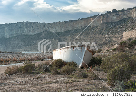 Abandoned boat on Zapallo Bay shore with cliffs in the background. Episkopi, Limassol District, Cyprus 115667835