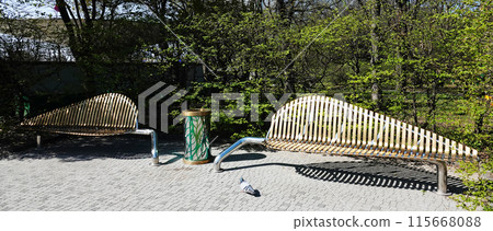 Kyiv, Ukraine April 11, 2024: Gilded bench in the summer park of the Pechersk Botanical Garden of the city of Kyiv 115668088