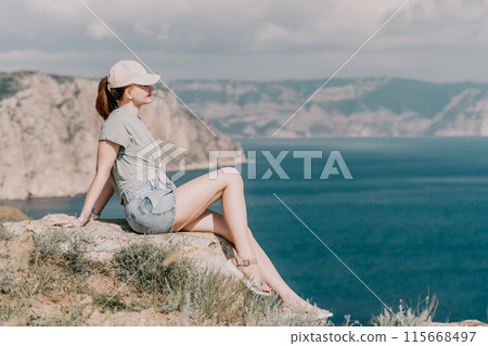 Woman travel sea. Happy tourist in hat enjoy taking picture outdoors for memories. Woman traveler posing on the beach at sea surrounded by volcanic mountains, sharing travel adventure journey Woman travel sea. Happy tourist in hat enjoy taking picture outdoors for memories. Woman traveler posing on the beach at sea surrounded by volcanic mountains, sharing travel adventure journey 115668497