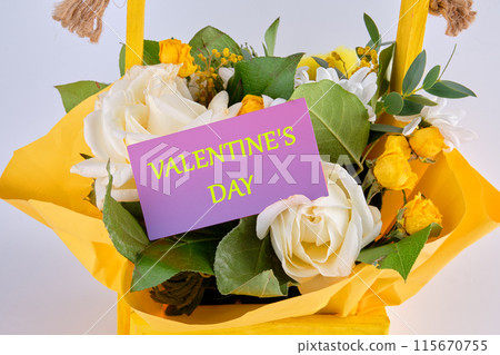 VALENTINE'S DAY text on a purple business card in a basket with flowers 115670755