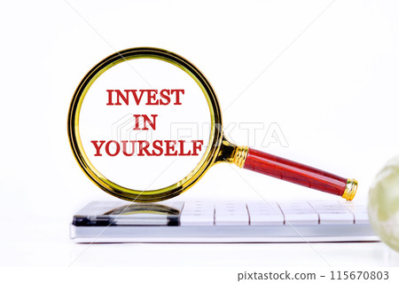 Business and Invest in yourself concept. Copy space. Concept words Invest in yourself through the lens of a magnifying glass on a light background 115670803