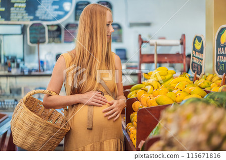A pregnant woman is at a fruit stand in a grocery store Pregnant woman buying organic vegetables and fruits at Mexican style farmers market A pregnant woman is at a fruit stand in a grocery store Pregnant woman buying organic vegetables and fruits at Mexican style farmers market 115671816