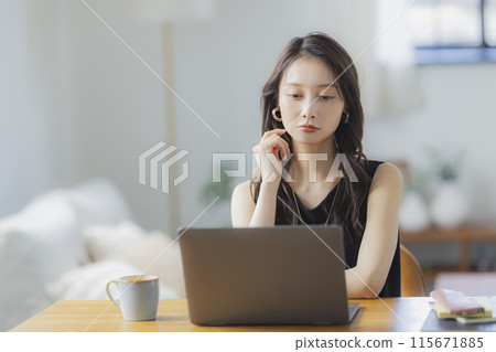 一位年輕女子在客廳在家工作 115671885