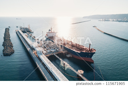 Aerial view of a large oil tanker docked at a pier in the port in process of loading. Aerial view of a large oil tanker docked at a pier in the port in process of loading. 115671905
