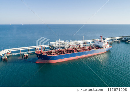 Aerial view of a large oil tanker docked at a pier in the port in process of loading. Aerial view of a large oil tanker docked at a pier in the port in process of loading. 115671908