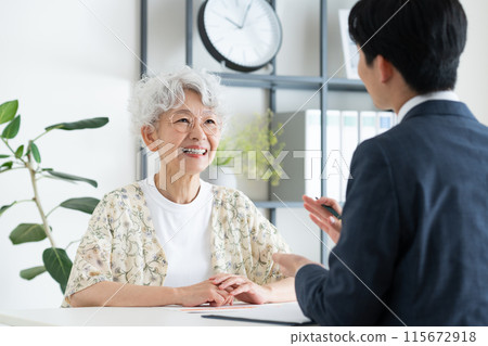 Elderly woman consulting with a businessman Elderly woman consulting with a businessman 115672918