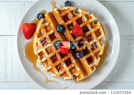 A plate of waffles with blueberries and strawberries on top A plate of waffles with blueberries and strawberries on top 115673384