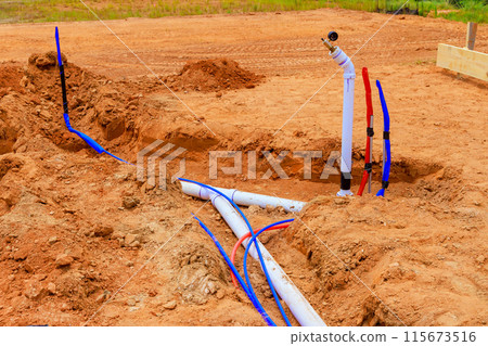 Before pouring concrete into foundation of new home by laying underground water lines sanitary pipes 115673516