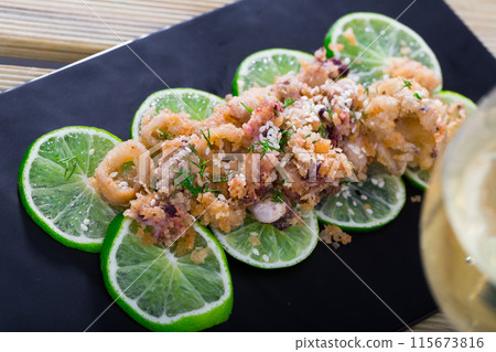 Calamari and sepia tempura on limes with wine Calamari and sepia tempura on limes with wine 115673816