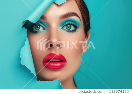 Woman peeking through torn blue paper 115674123