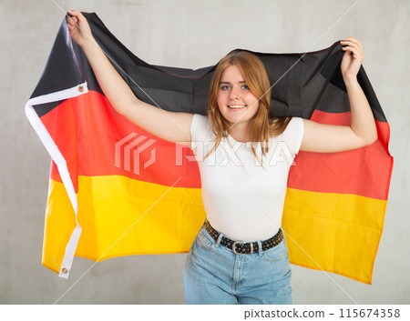 Attractive female student holding Germany flag Attractive female student holding Germany flag 115674358