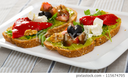 Toasts with guacamole, fresh vegetables, feta cheese Toasts with guacamole, fresh vegetables, feta cheese 115674705