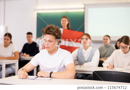 Young teacher stands behind students with flag of Denmark 115674712